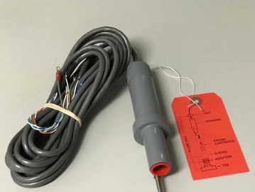A gray probe with a long cable and a red tag attached, lying on a white surface.