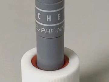 A gray cylindrical electronic component with a metal connector and white plastic base.
