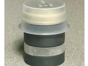 Stack of black and translucent plastic rings on a speckled surface.