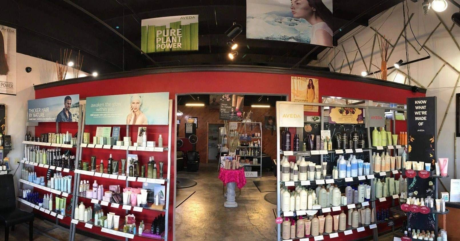 Aveda product displays with hair and skincare items in a well-lit salon area.