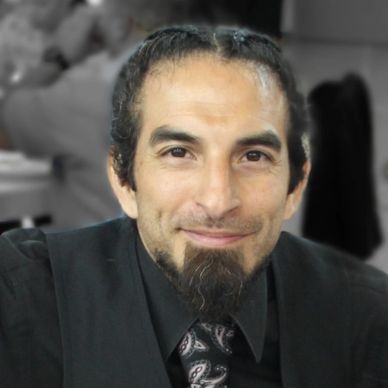 Man with a goatee smiling at the camera.