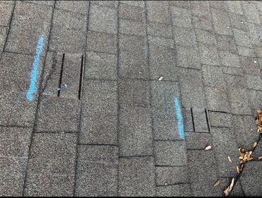 Roof shingles with blue markings and small rectangular cutouts.