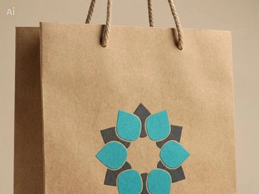 Brown paper bag with blue and black floral design and rope handles.