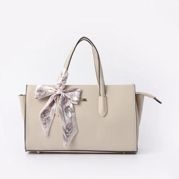 Elegant beige handbag with floral scarf tied to handle.