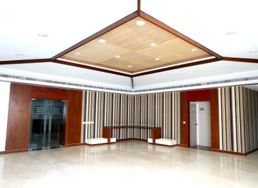 A modern, empty room with striped walls and a wooden ceiling panel.