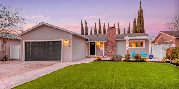 Single-story house with a manicured lawn at sunset.