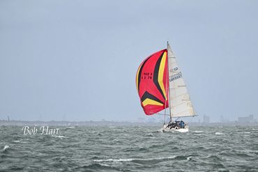 Sailboat with colorful sail on open water.