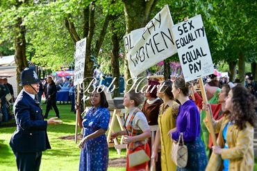 Women protest for equal pay and sex equality outdoors.