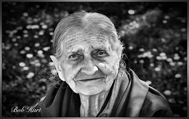 Black and white portrait of an elderly woman with a gentle smile.