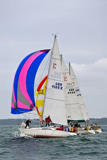 Two sailboats racing with colorful spinnakers on the water.
