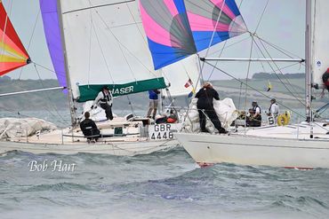 Sailboats racing on choppy water under cloudy skies.