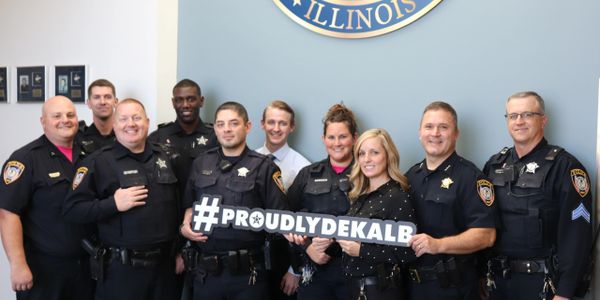 Ten officers posed with #ProudlyDeKalb sign.