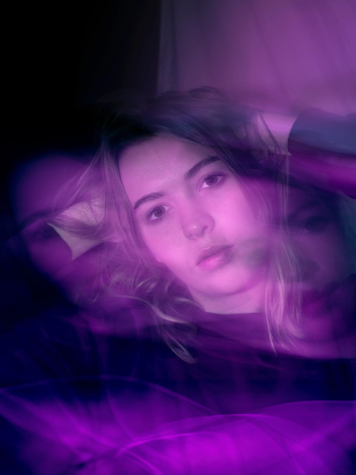 Young woman with a dreamy purple light effect around her face.