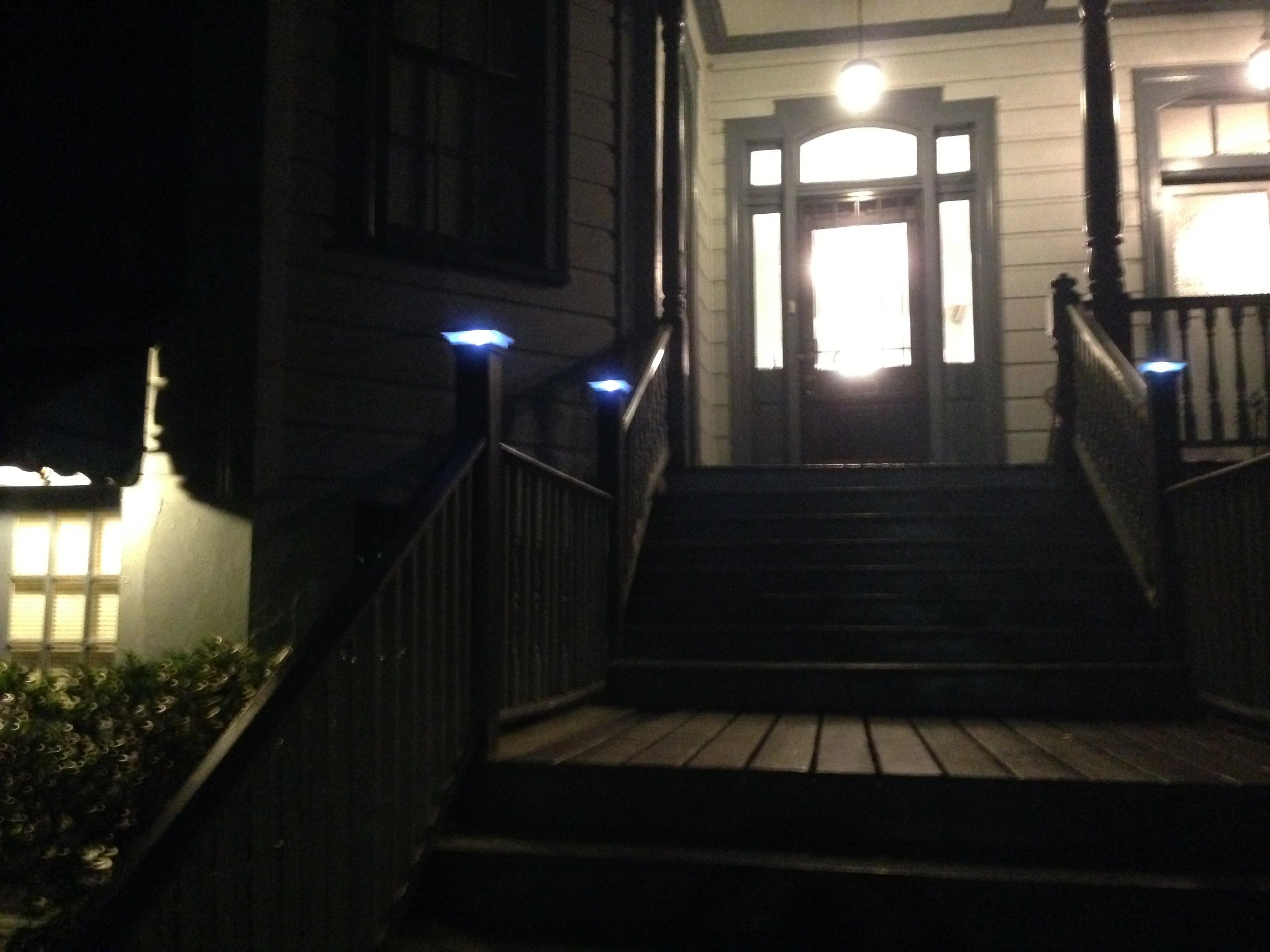 a nighttime exterior view of a house with stairs and railing