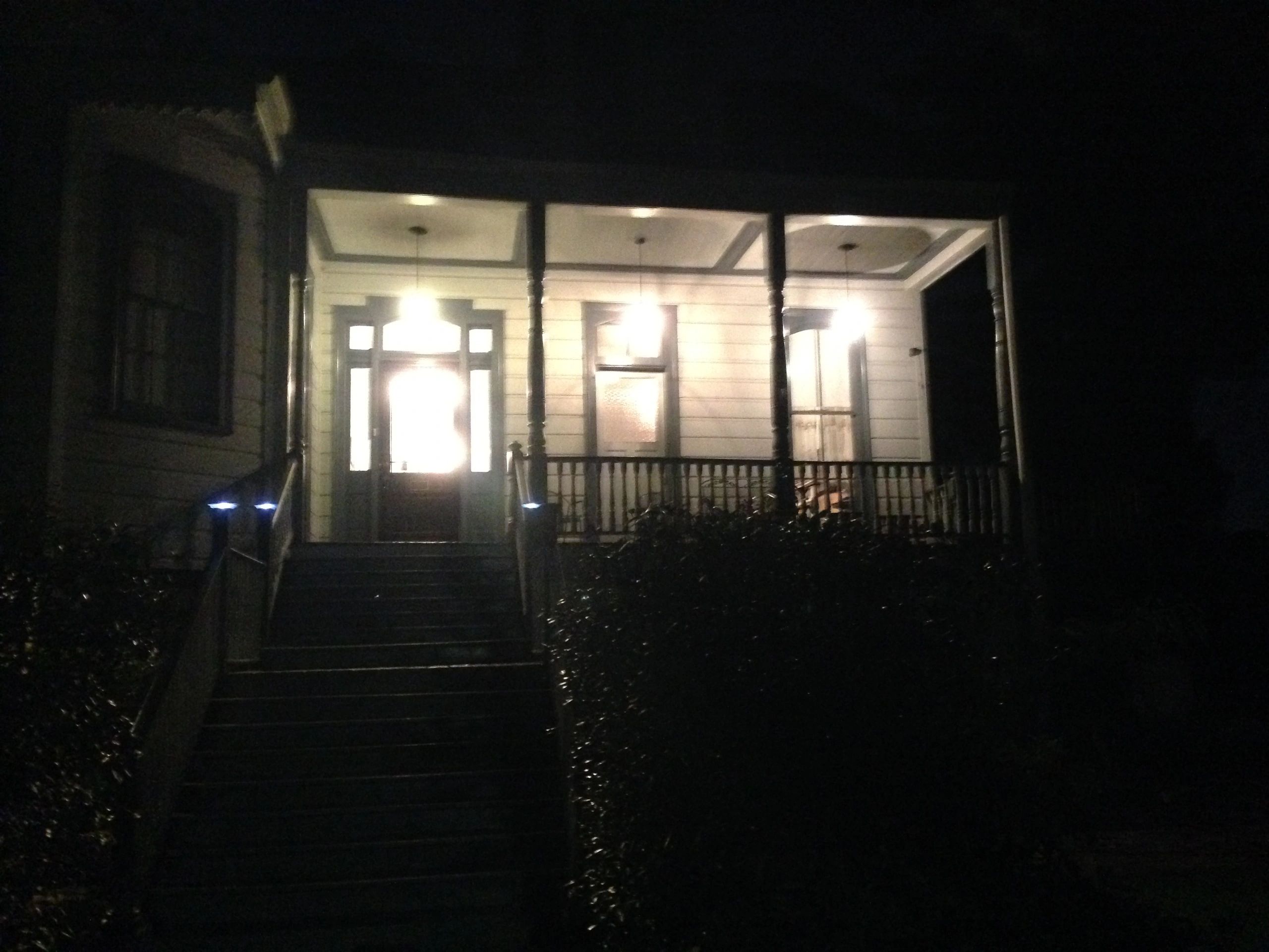 A house with a porch and stairs at night