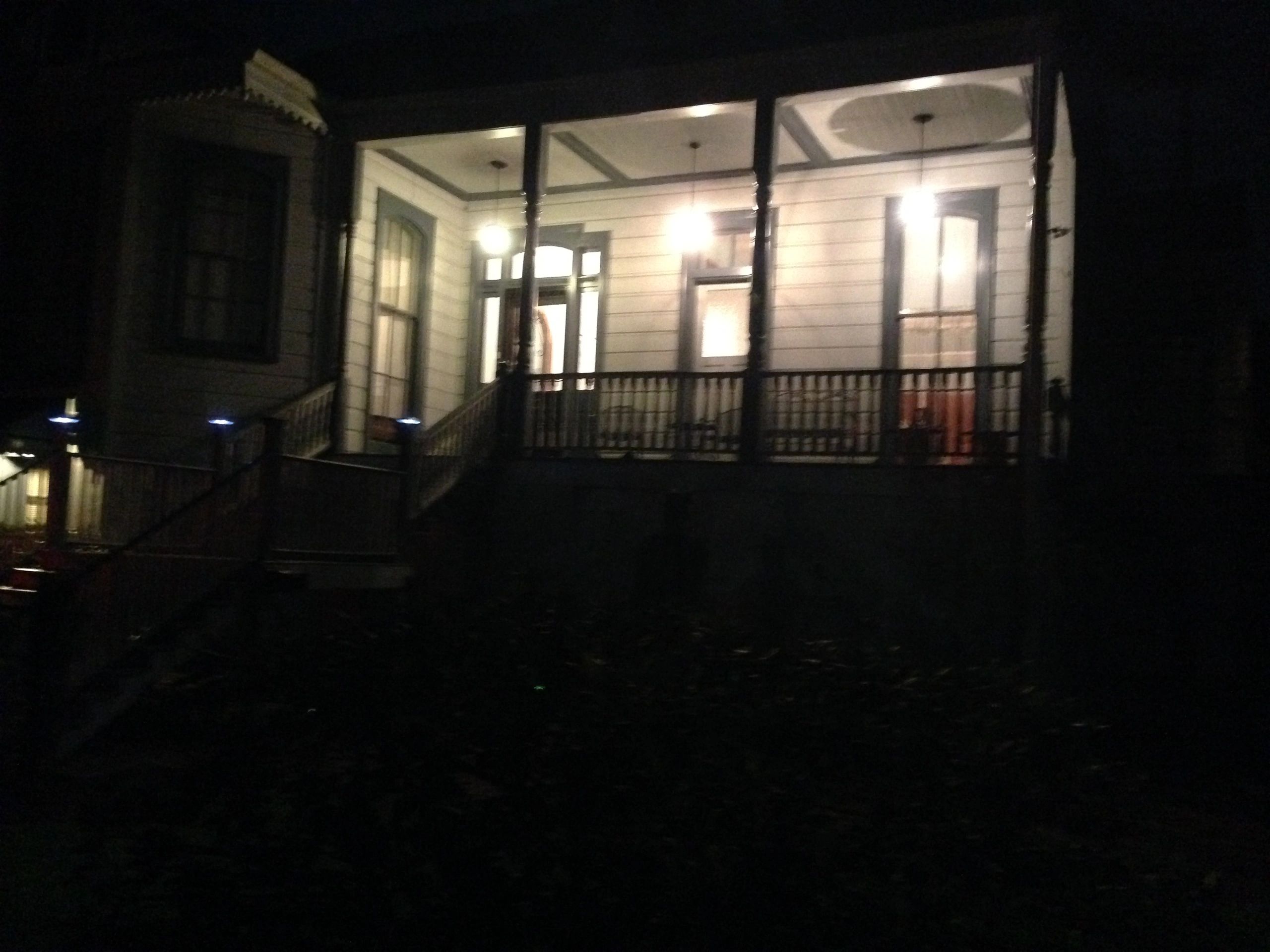A house with a porch and lights on at night