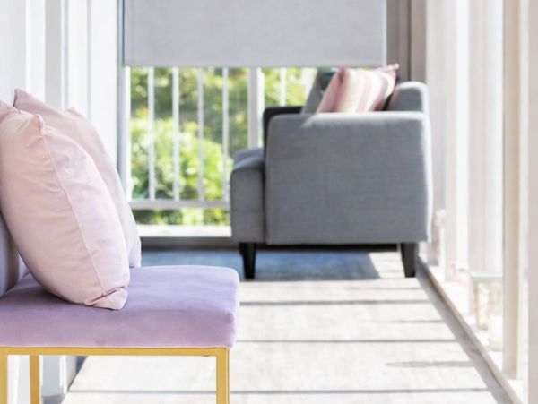Modern seating area with a pink cushioned bench and a gray sofa.
