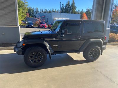 Black Jeep Wrangler parked under a covered area.