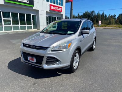 Silver Ford SUV parked in front of a dealership.