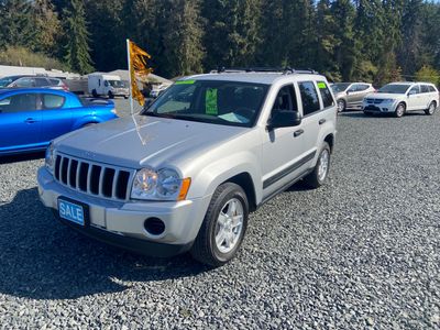 Silver Jeep SUV for sale in a gravel lot.