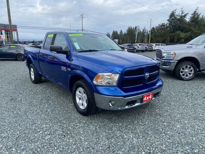 Blue Dodge Ram pickup truck parked on gravel.