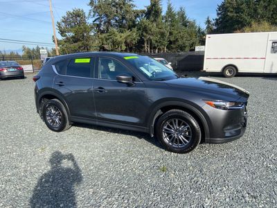 Dark gray SUV parked on gravel lot.