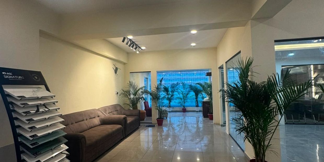 Modern lobby with sofa, plants, and tile floor.