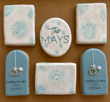 Decorative cookies with floral designs and wedding rings, personalized with "The Mays" and wedding date.