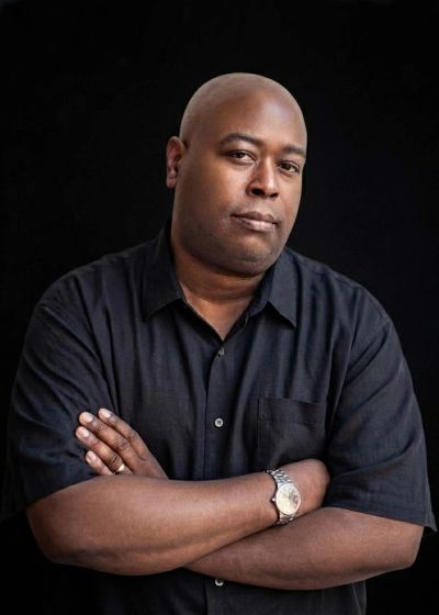 Man with folded arms looking confidently at the camera.