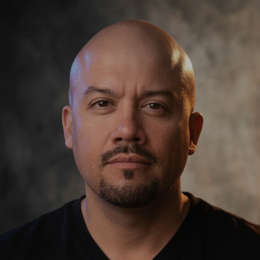 Portrait of a bald man with a goatee.