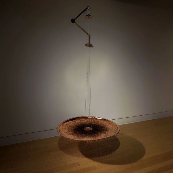 Hanging circular copper artwork casting shadows on the floor.