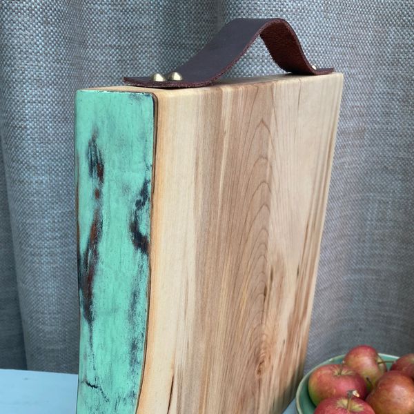 Wooden board with a blue/green edge on table with fruit 
