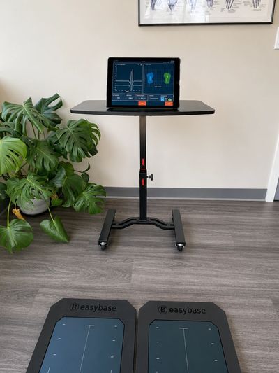 Tablet on a stand with foot pressure mats on the floor.