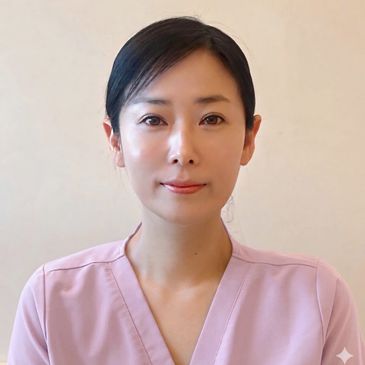 Portrait of a woman in a light pink top against a plain background.