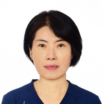 Portrait of a woman with short black hair wearing a navy blue top.