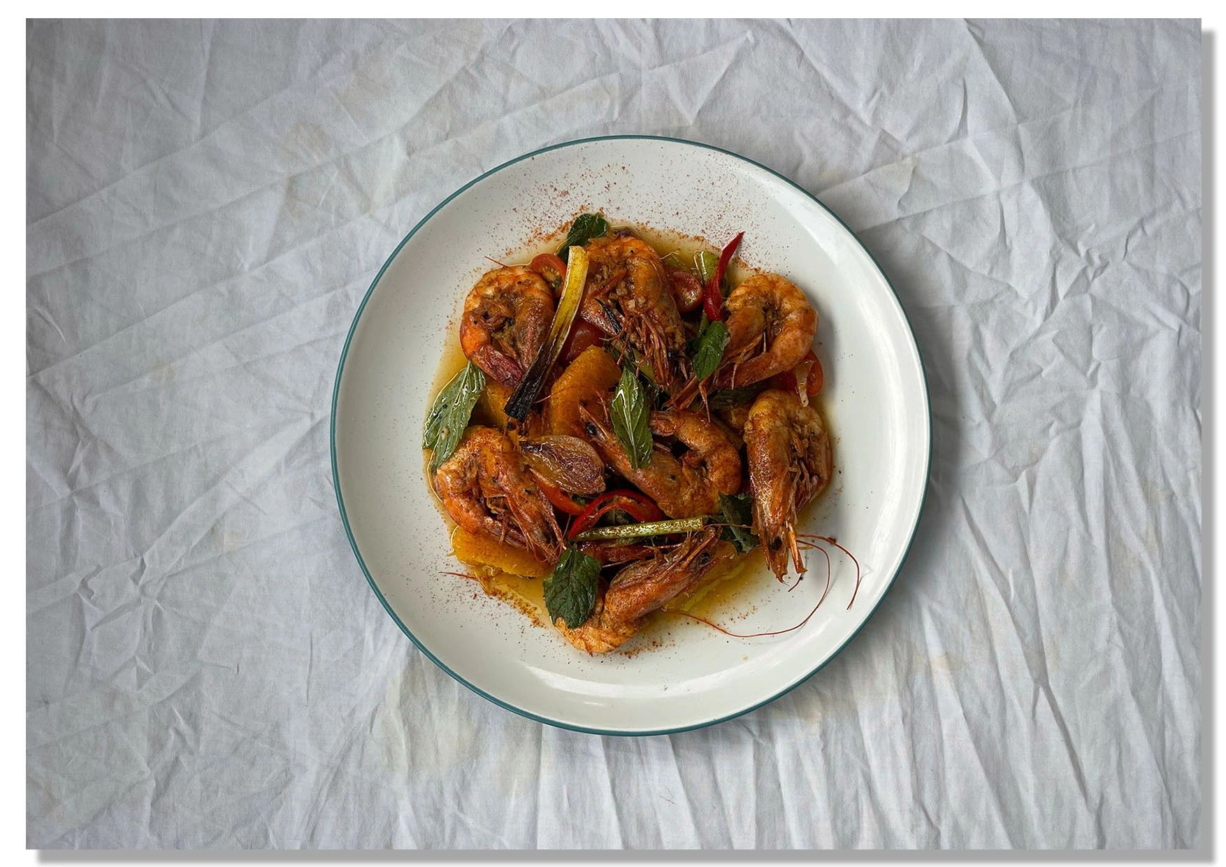Plate of cooked shrimp with herbs and spices.