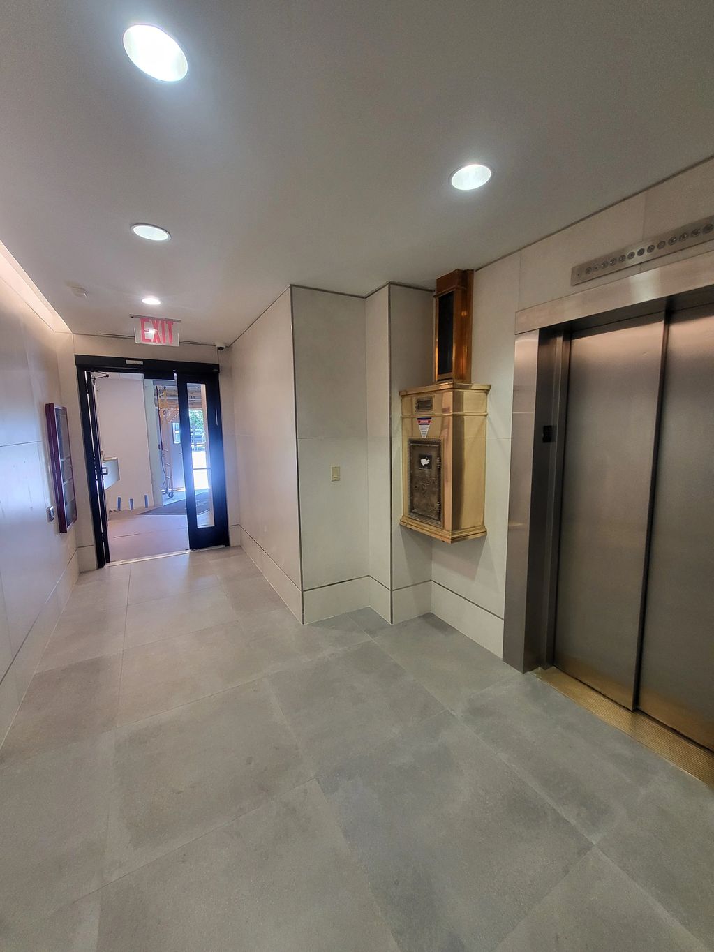 Modern lobby with elevator and exit door.