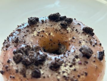 Close-up of a donut topped with crushed chocolate cookies.