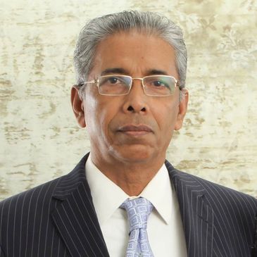 Portrait of an elderly man in a suit and glasses.