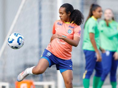 Female soccer player practicing with a ball during training.