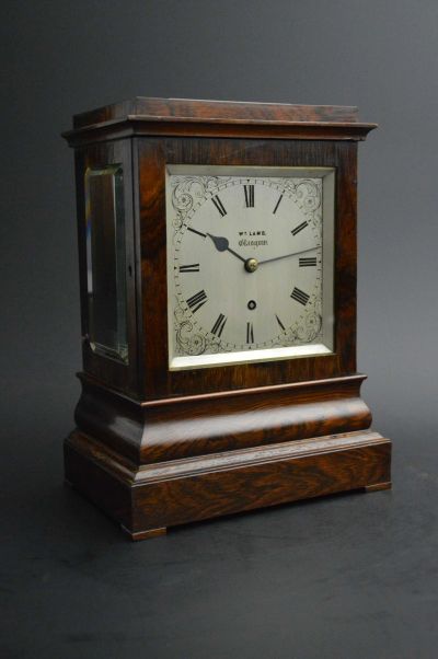 Antique wooden mantel clock with Roman numerals.