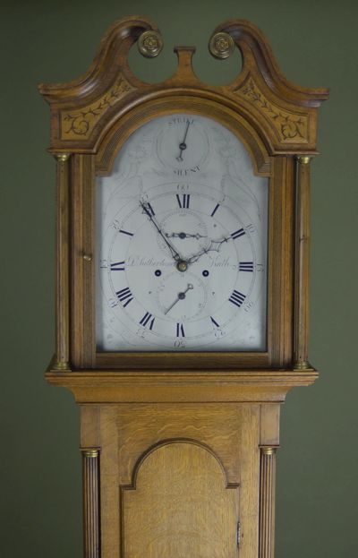 Elegant wooden grandfather clock with intricate carvings and Roman numerals.