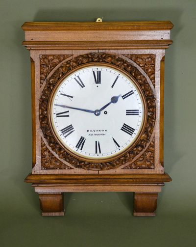 Antique wooden wall clock with Roman numerals and intricate carvings.