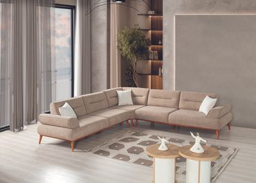 Modern beige sectional sofa in a bright living room with large windows.