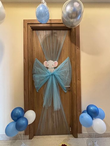 Door decorated with blue tulle, balloons, and an elephant cutout.