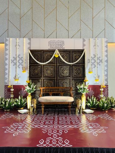 Elegant traditional stage setup with floral decorations and intricate patterns.