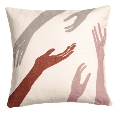Decorative pillow with artistic hand designs in neutral tones.