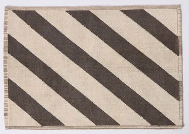 Rectangular rug with diagonal black and white stripes.