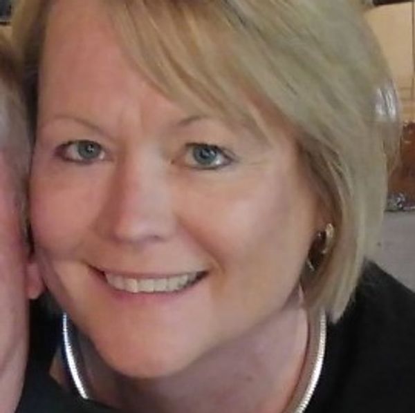 Smiling woman with blonde hair and blue eyes.