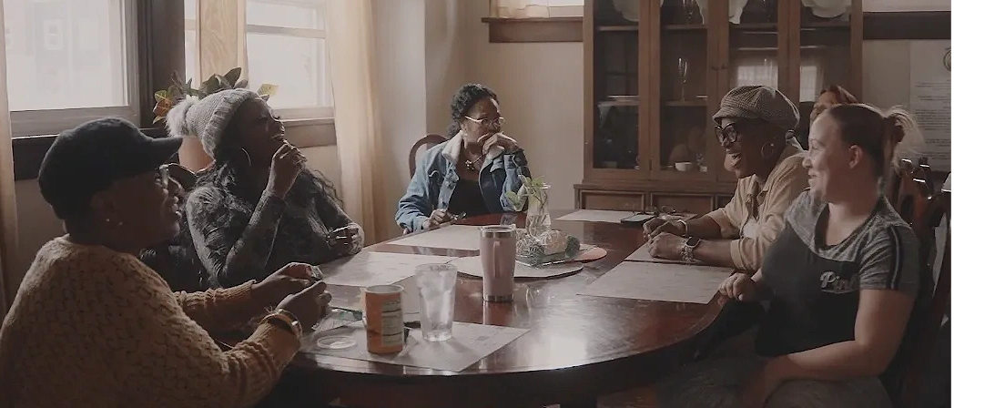 Sisters in Christ women in the housing and recovery program talking at a table.